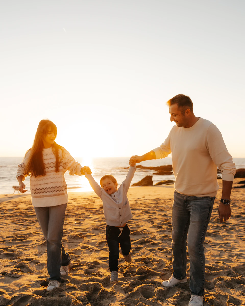 Família compartilhando um momento na praia ao entardecer